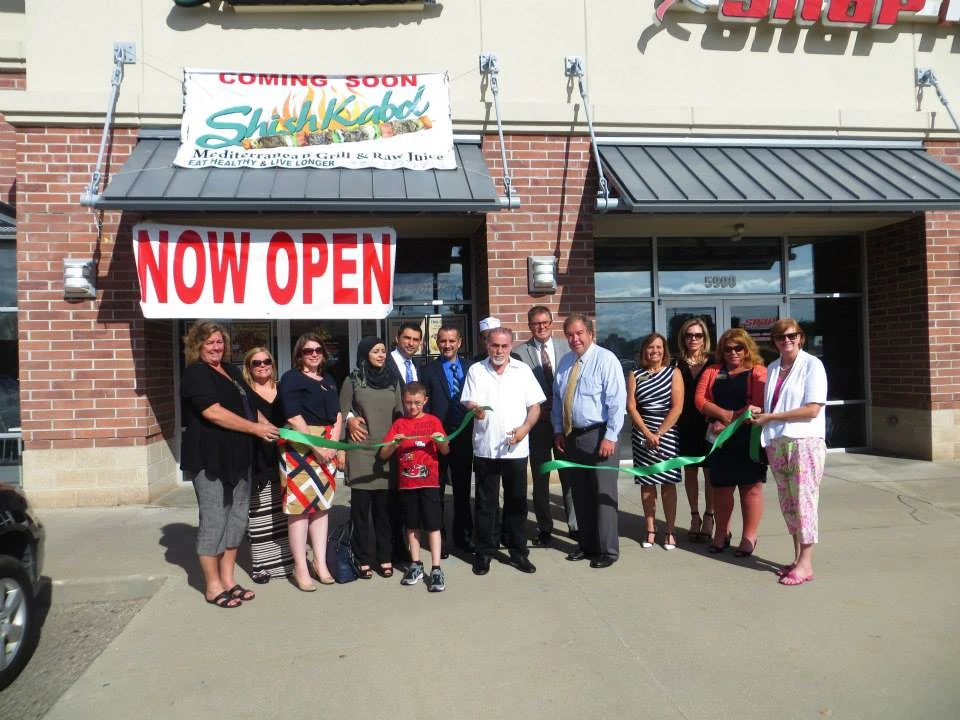 Grand opening ribbon cutting outside a new Shish Kabob Express location